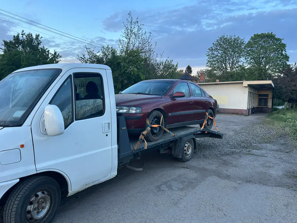 Bordó Volvo S60 felrakva NV Autómentő trélerre alkonyatkor